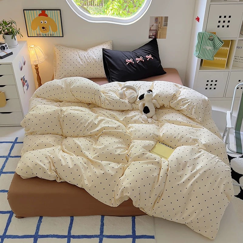 Soft cotton duvet cover with brown polka dots paired with a light brown fitted sheet and cozy dorm lighting