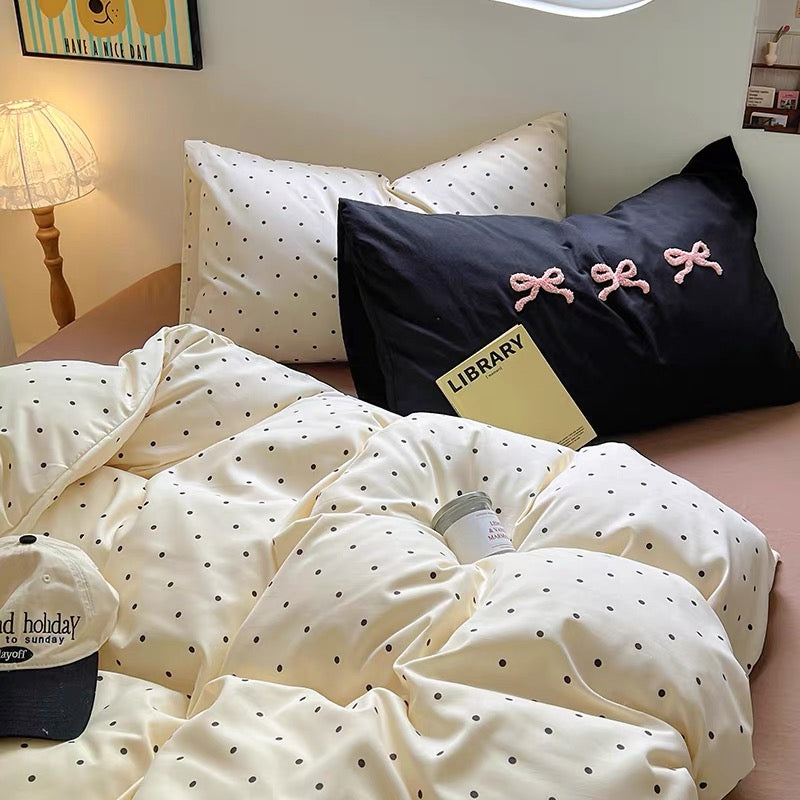 Soft cotton duvet cover with brown polka dots paired with a light brown fitted sheet and cozy dorm lighting