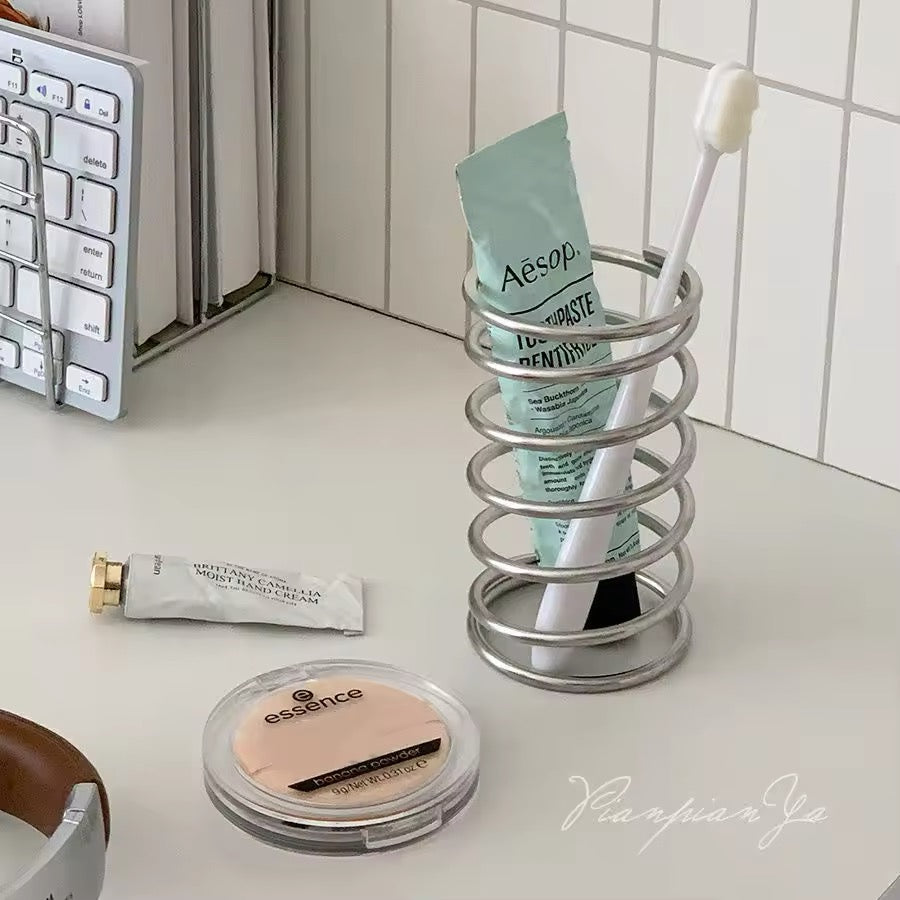 Makeup brushes neatly organized in the stainless steel holder on a vanity table