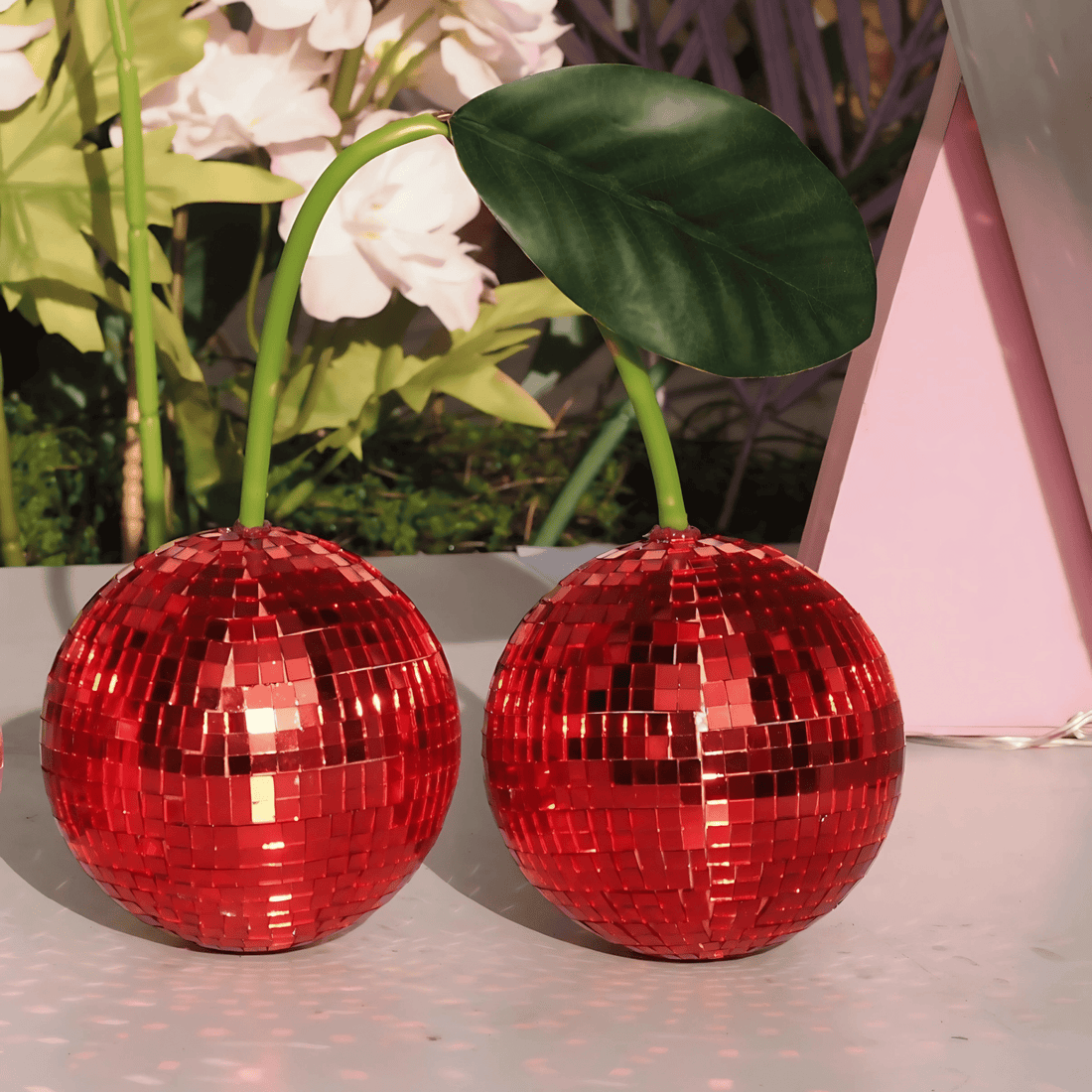 Red cherry disco ball set on shelf sparkling in sunlight