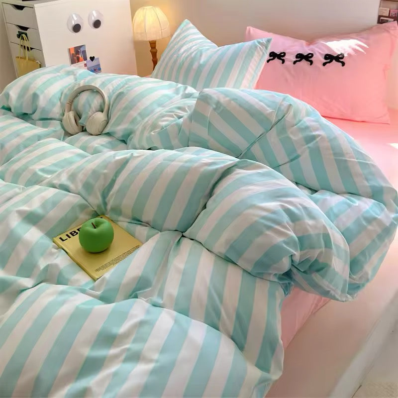 Coquette aesthetic pastel stripe bedding set with pink bow pillowcases in a cozy bedroom decor.