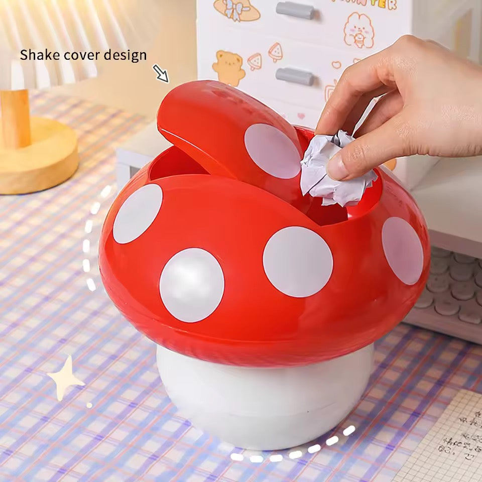 Red and white polka dot mushroom-shaped trash can with a hand disposing of waste.