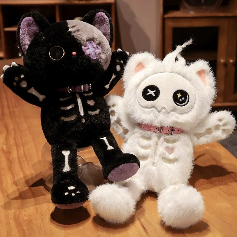 Two plush toys, one white and one black, with skeleton designs on a wooden surface.