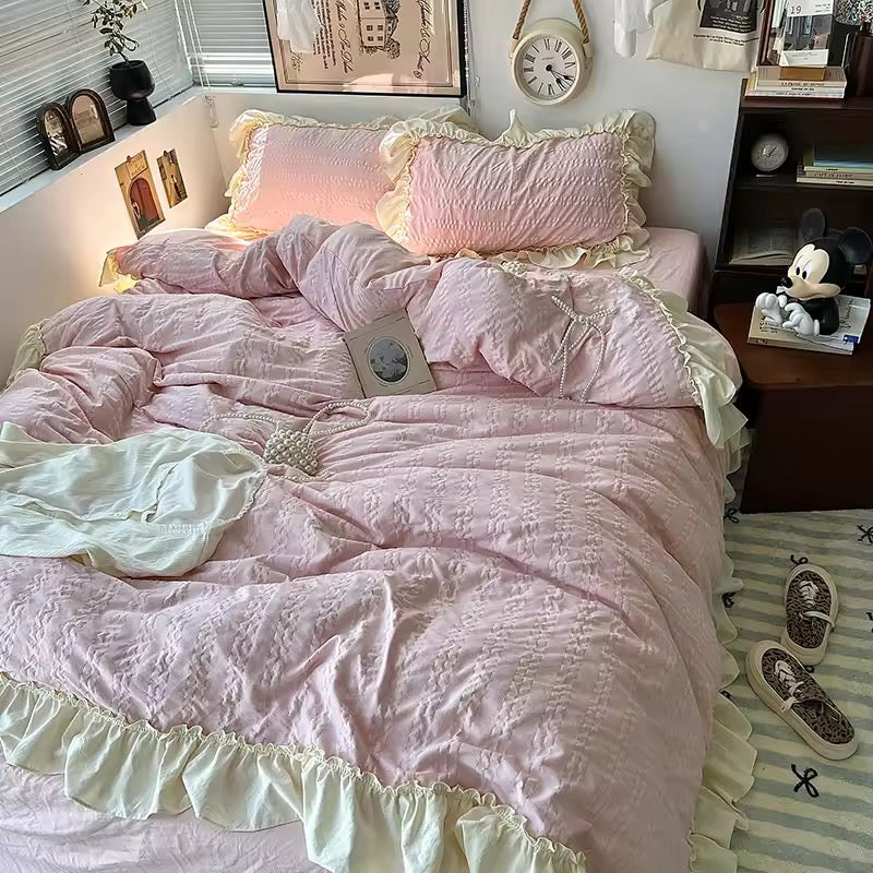 Pink ruffled Korean princess bedding set with cream lace trim on a cozy bed