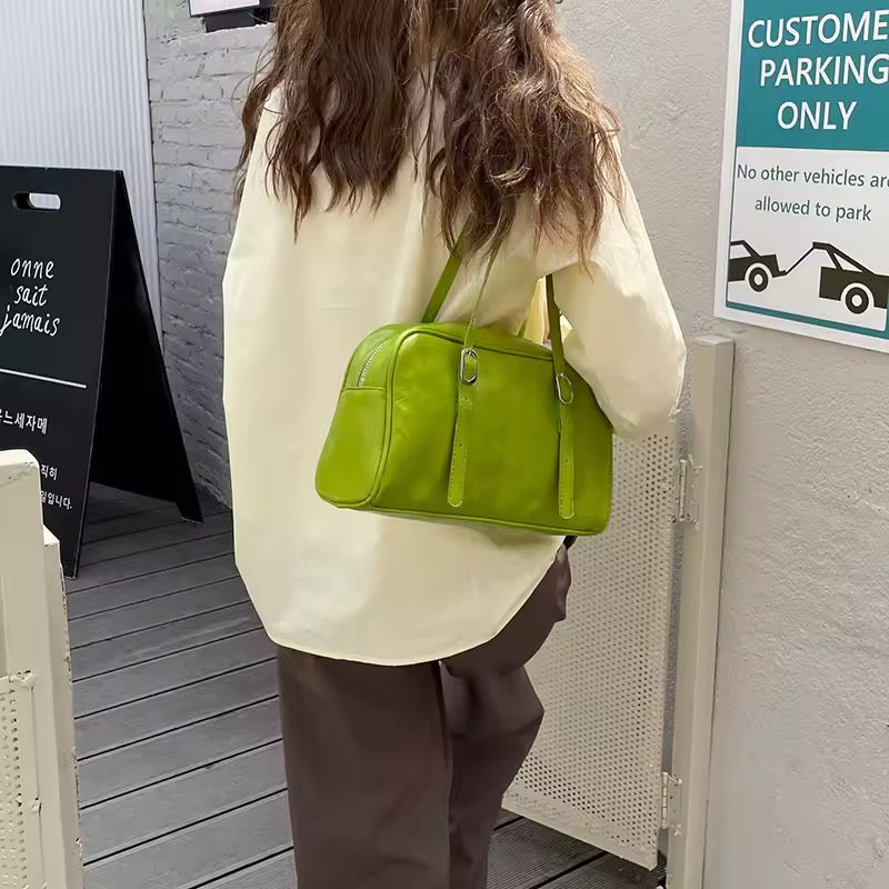 Person wearing a bright green handbag in an outdoor setting with a 'Customs Parking Only' sign.