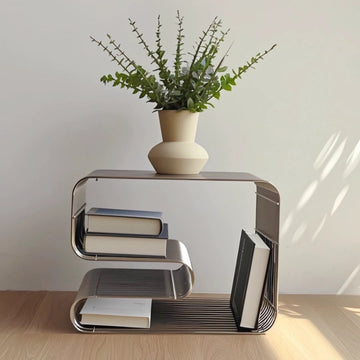 Modern side table with books and a plant on a wooden floor.