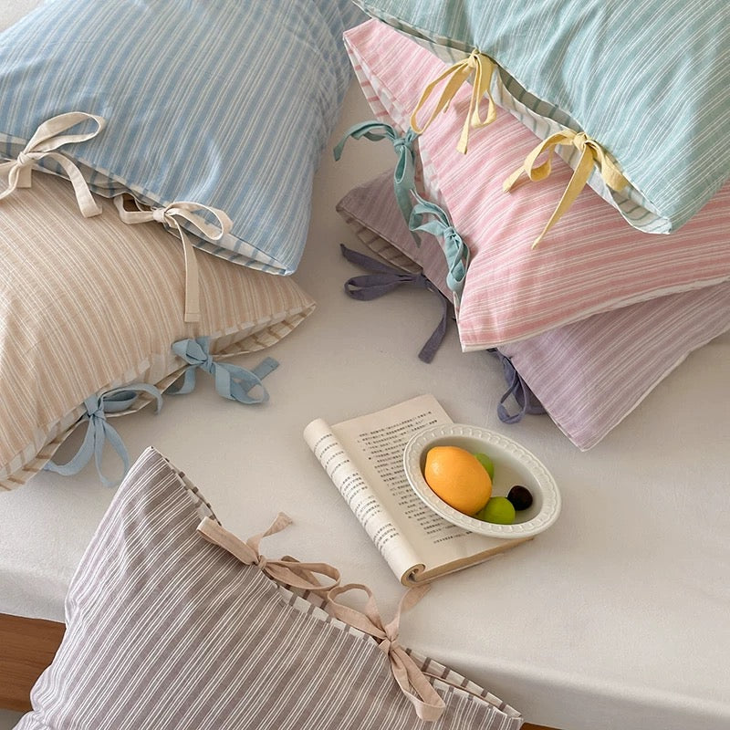 Pastel striped bow pillow cases in soft cotton, perfect for aesthetic bedrooms.