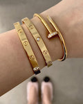 Woman wearing the Nail Bracelet in gold, showcasing minimalist design