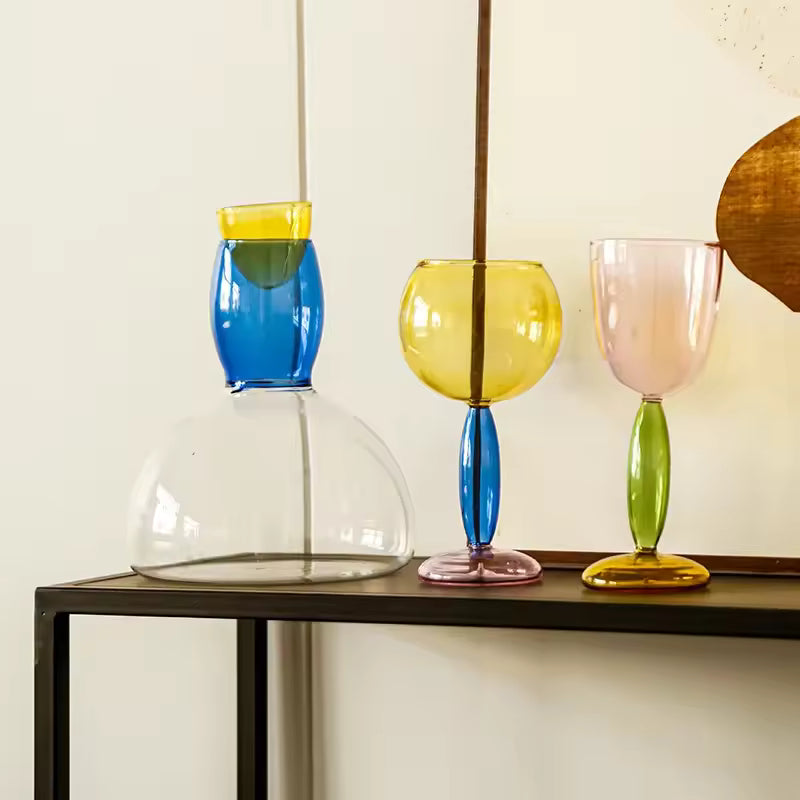Colorful glass lamps on a table against a neutral wall
