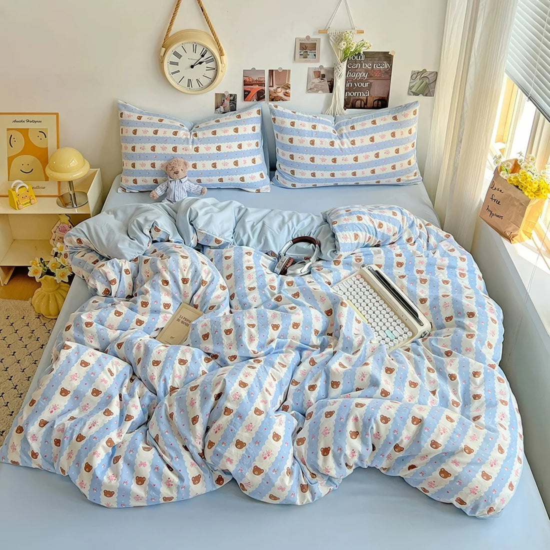 Aesthetic pastel blue bedding photographed on a cozy white bed with warm lighting.