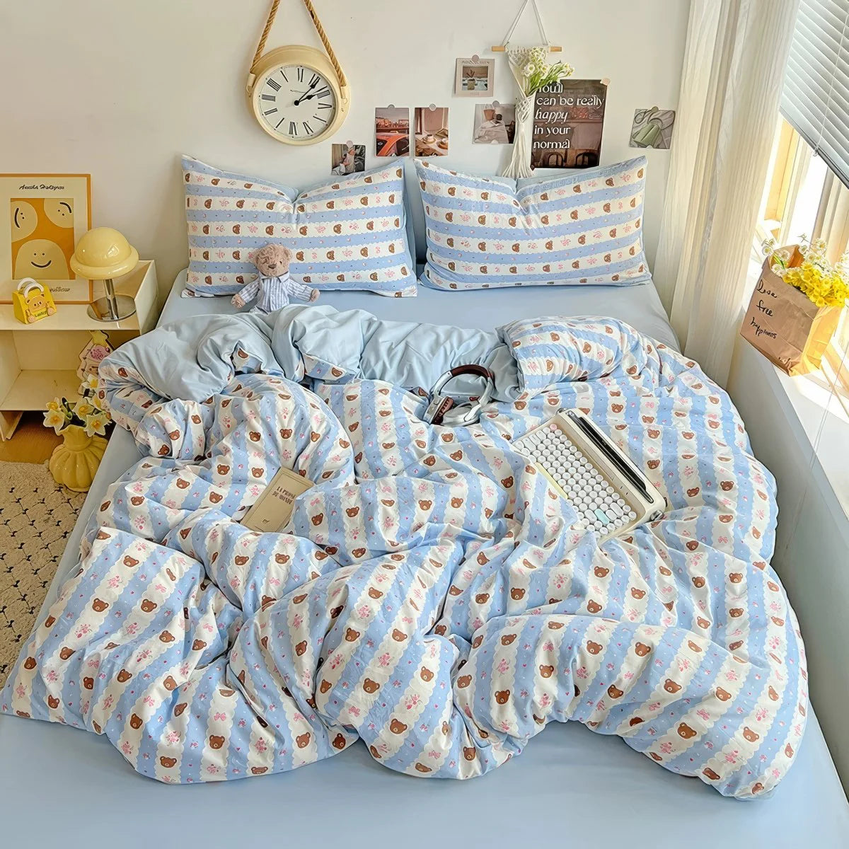 Aesthetic pastel blue bedding photographed on a cozy white bed with warm lighting.