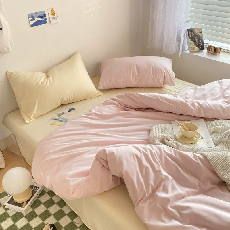 Cute aesthetic bed setup with pastel duvet cover, flat sheet, and matching pillowcases for college rooms.
