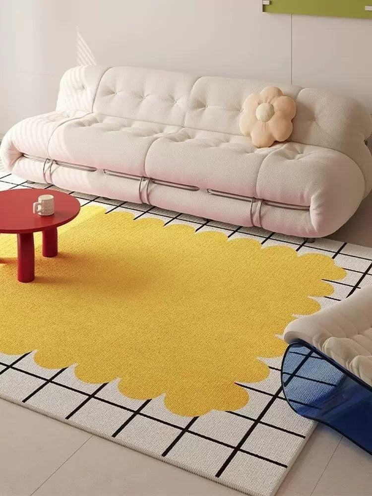 Yellow abstract rug on a tiled floor with a white sofa and red table in the background.