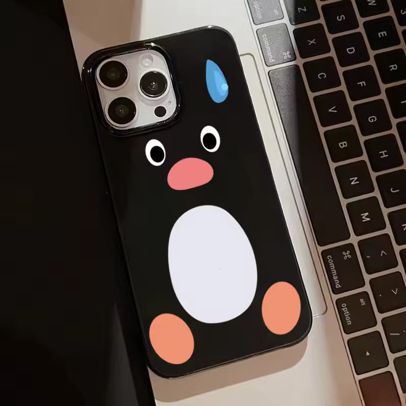 Phone case with a penguin design on a laptop keyboard