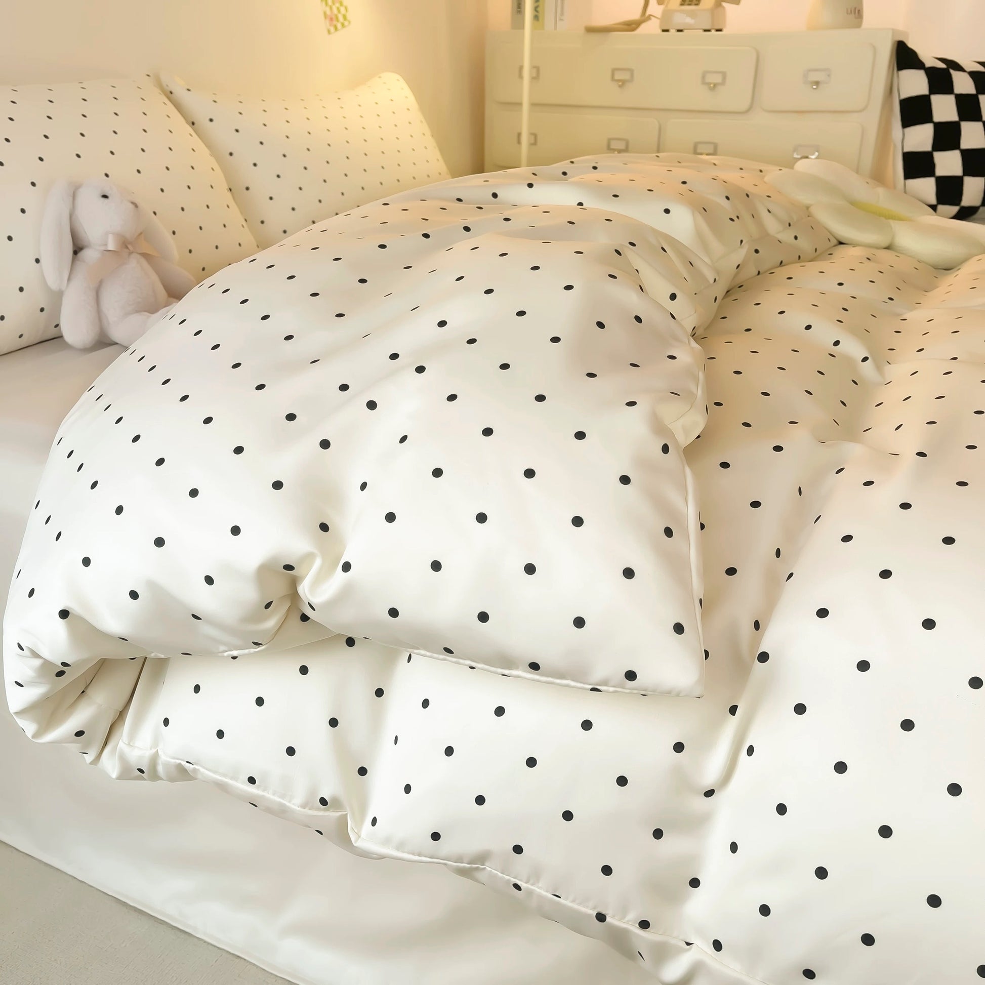 Coquette-style satin bedding with black dots and smooth pillow shams.