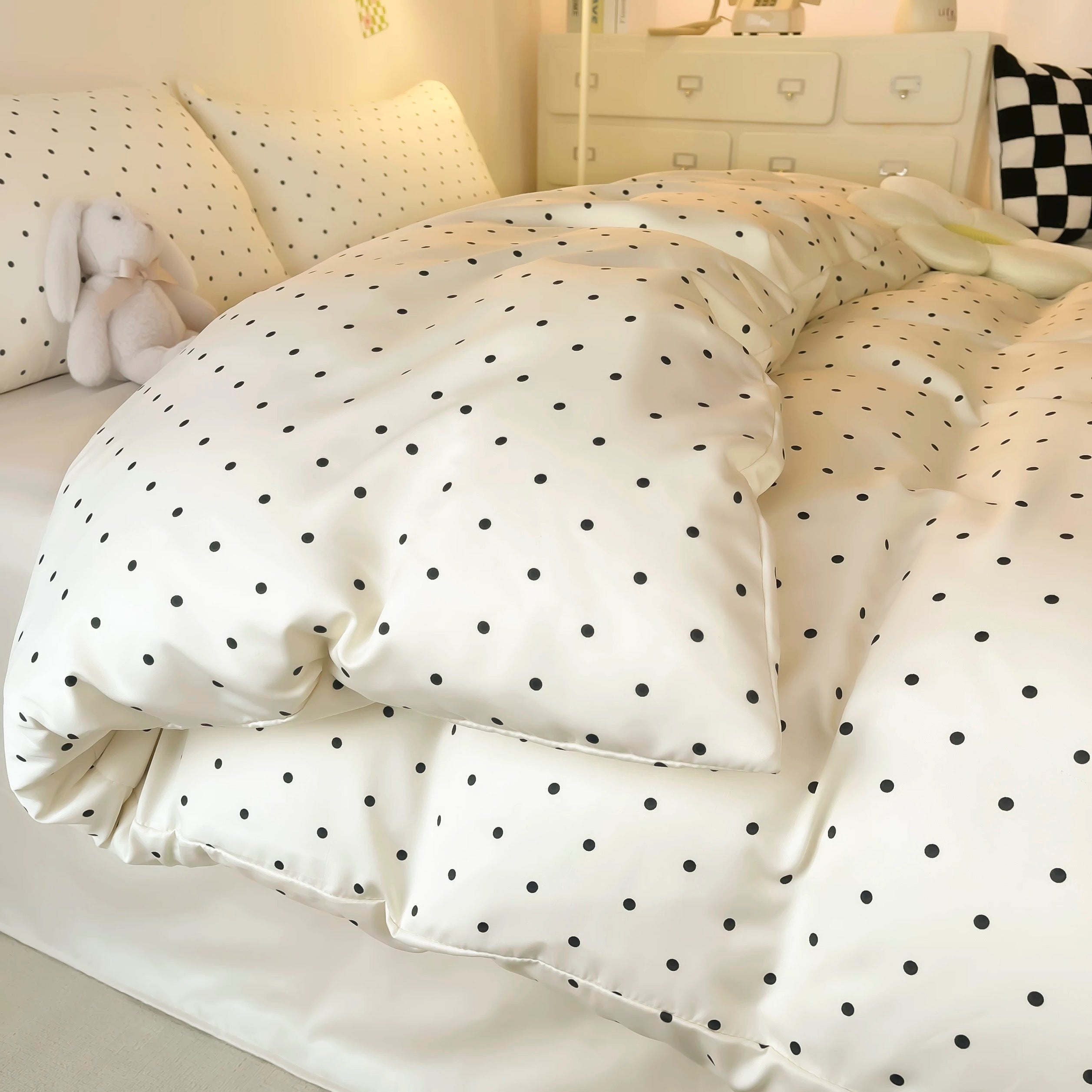 Coquette-style satin bedding with black dots and smooth pillow shams.