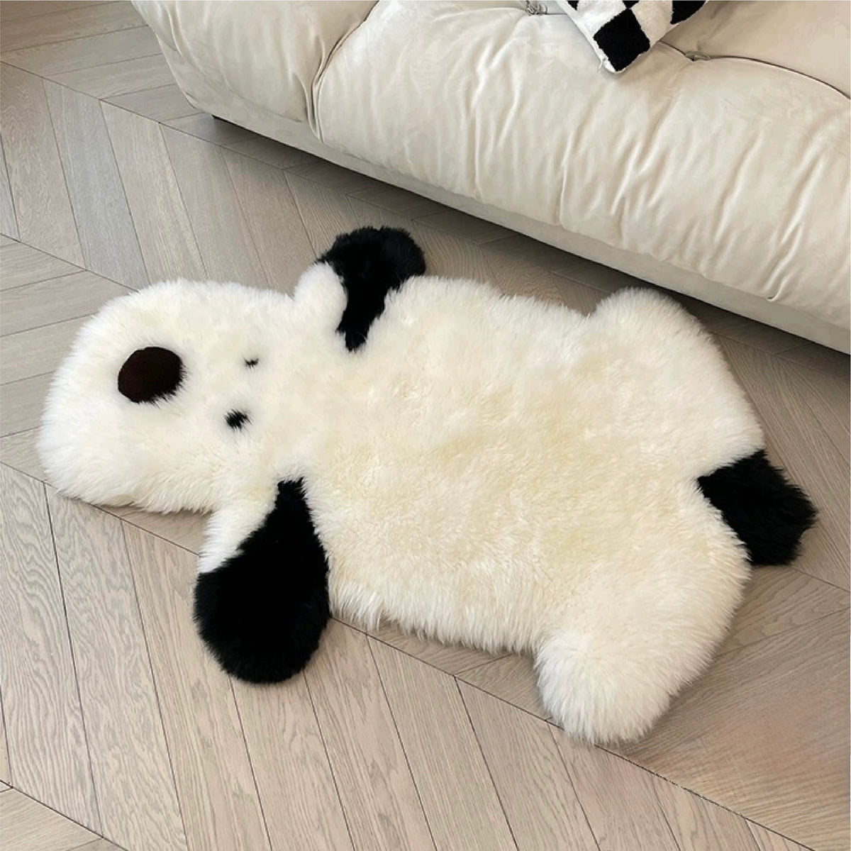 A cream animal shaped rug lies beside a white sofa, with black ears and paws around the dog outline.