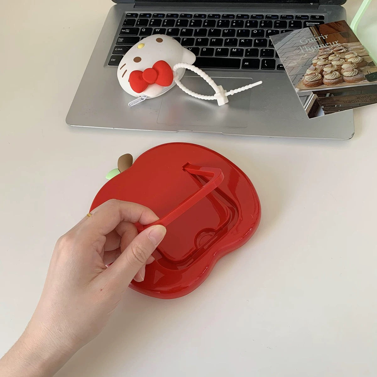 Kawaii mirror in green apple shape next to schoolgirl aesthetic books