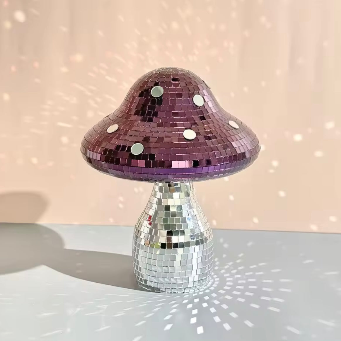 Handmade mushroom disco ball on pastel shelf with reflective lights
