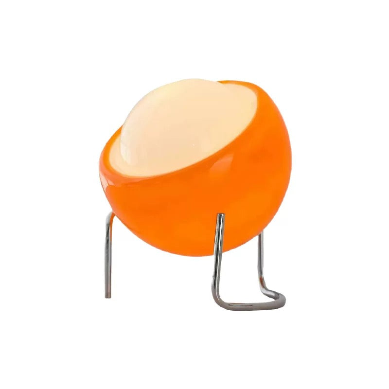 Orange and white spherical lamp on a stand with a white background