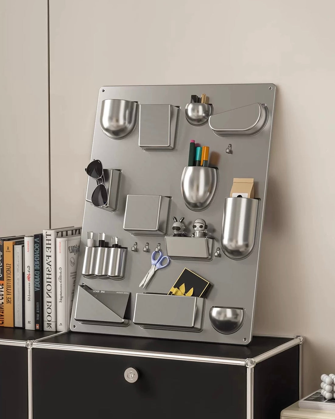 Metal magnetic board with various office supplies on a wall above a cabinet.