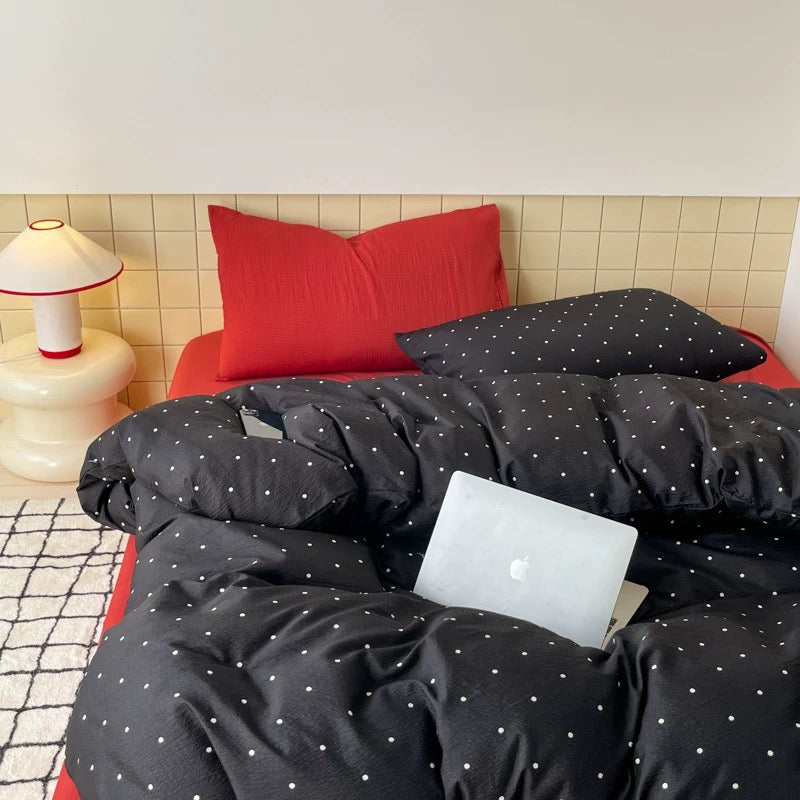 Black polka dot bedding set creating clean graphic look in college dorm room