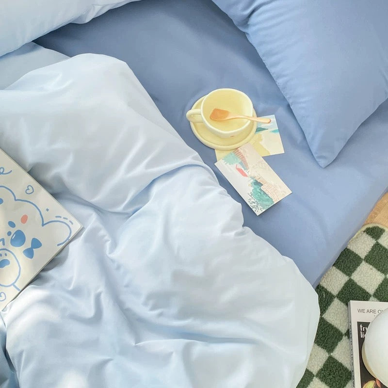 Minimalist blue bedding with duvet, sheet, and pillowcases for modern home.