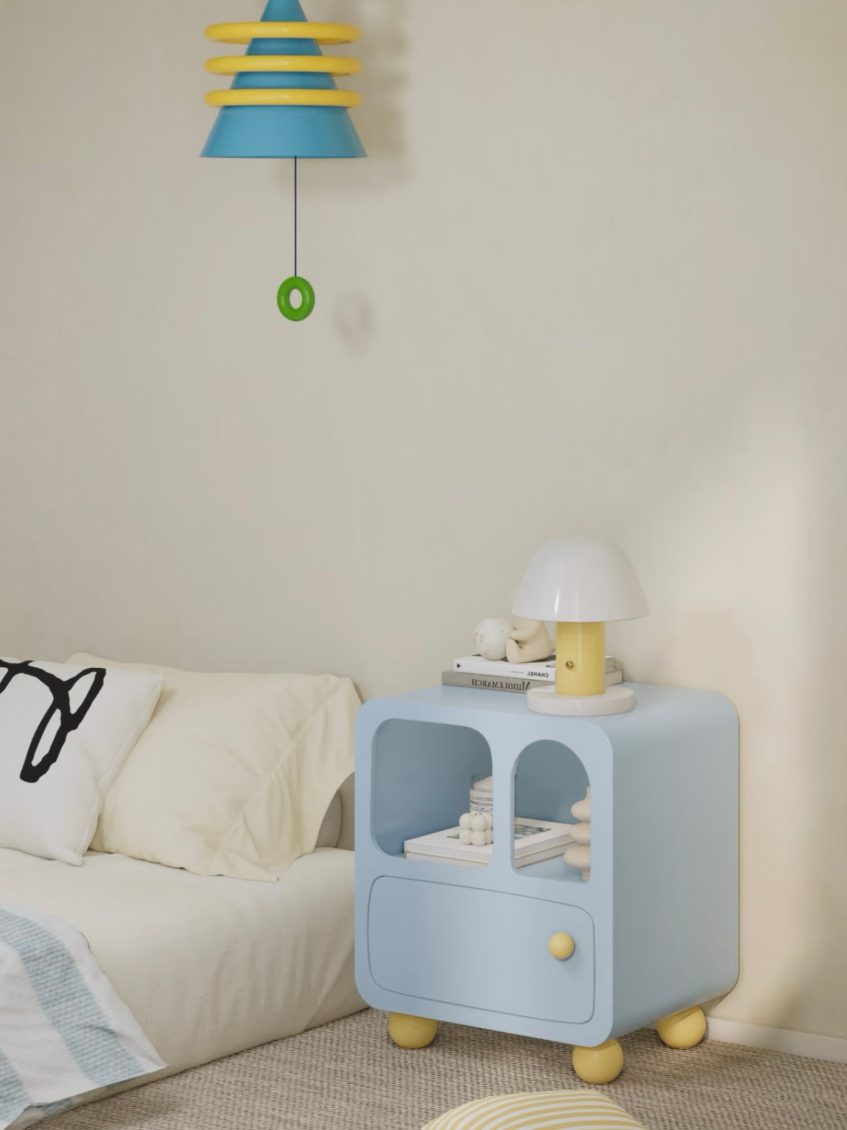 A blue bedside cabinet is shown from the side beside a bed, with a lamp on top and yellow feet below.