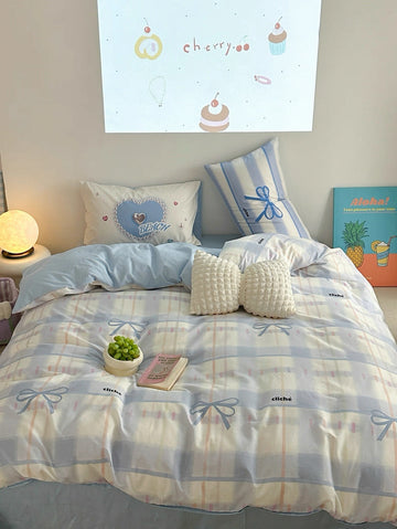 Bed with blue and white checkered bedding, decorative pillows, and a small plant on a nightstand.