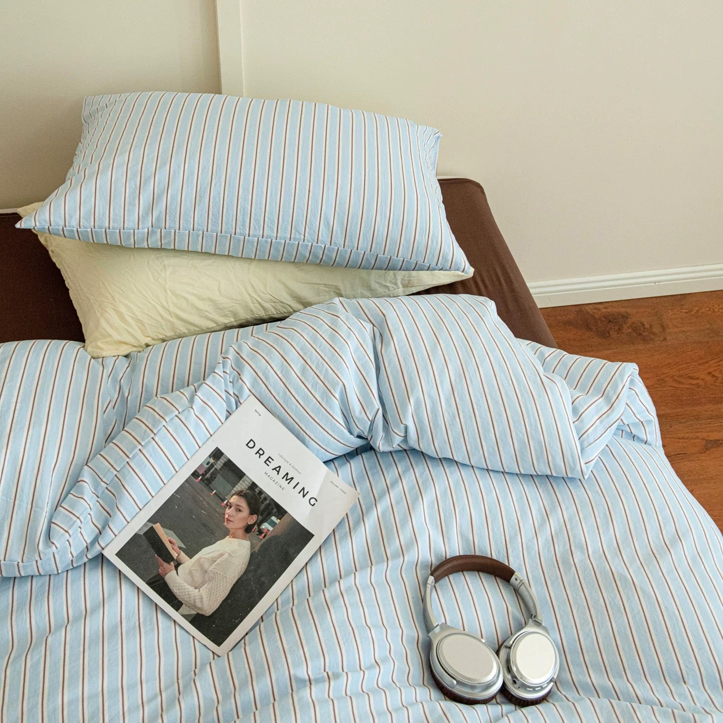 Striped bedding with a book and headphones on a bed