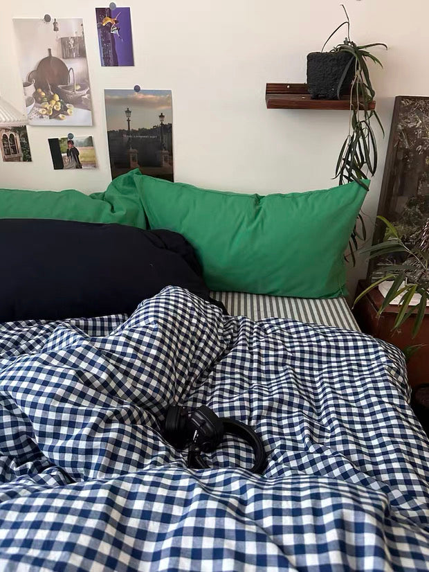 Blue plaid duvet cover layered on striped sheet for cottagecore bedroom decor inspiration.