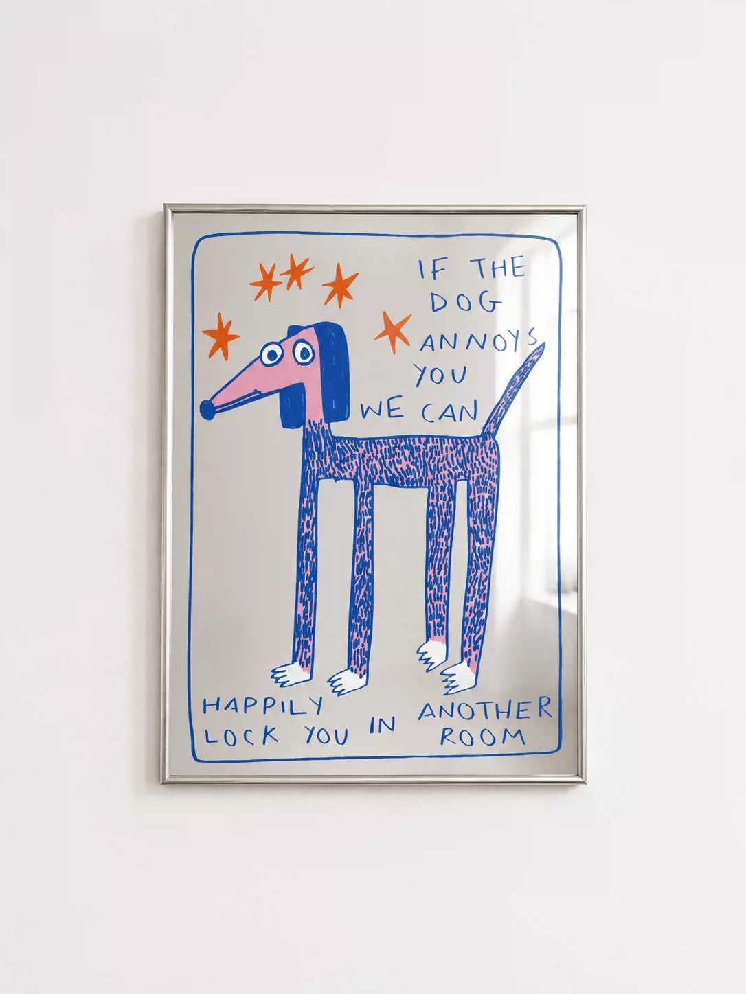 A blue dog illustrated mirror shows a long dog, orange stars and handwritten lettering inside a silver frame.