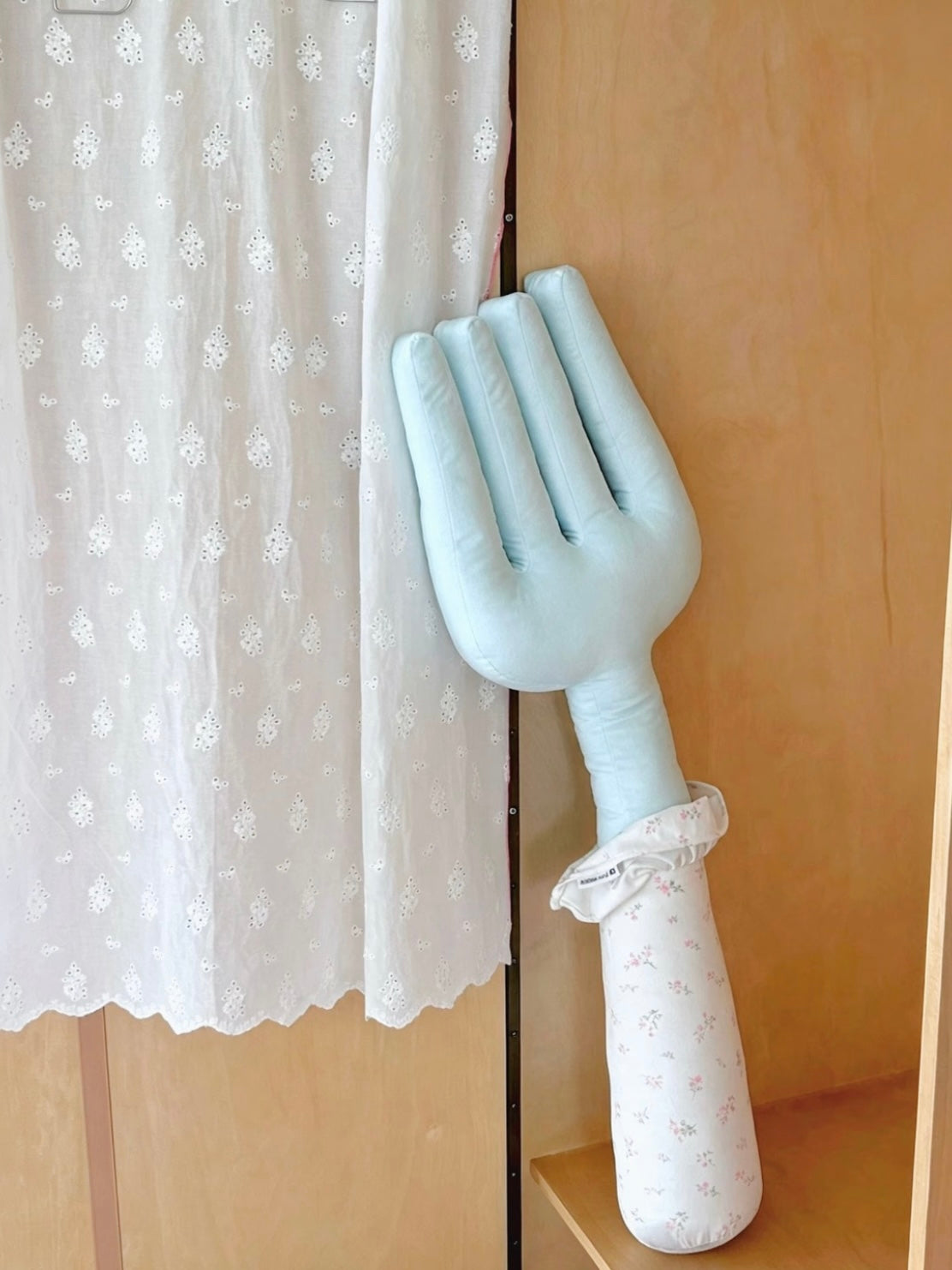 A blue fork pillow hangs upright, showing its long tines, pale floral handle and gathered fabric collar.