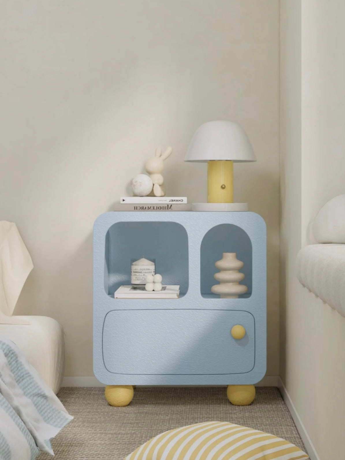 A blue nightstand shown from the front holds a white dome lamp above open cubbies and a closed drawer.