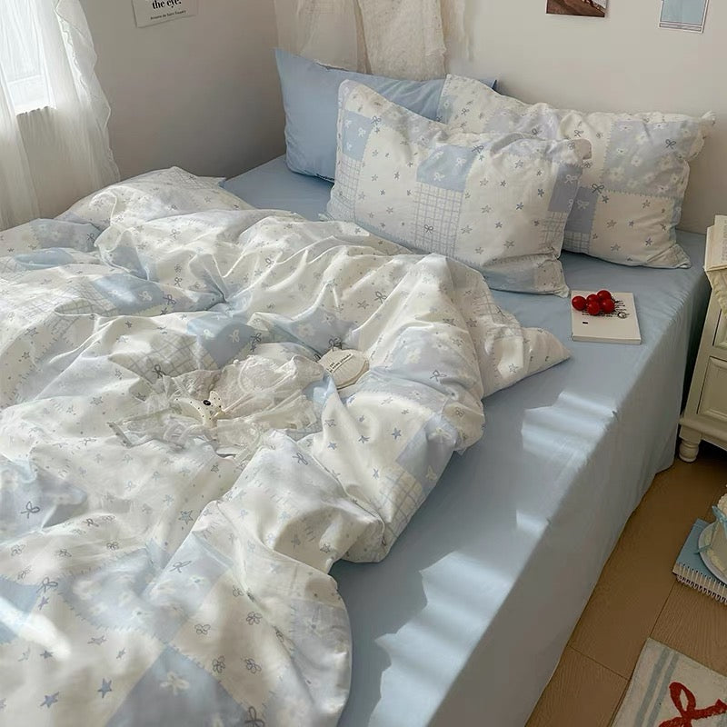 Pastel blue patchwork cotton duvet cover set styled in a kawaii dorm room with fairy lights.
