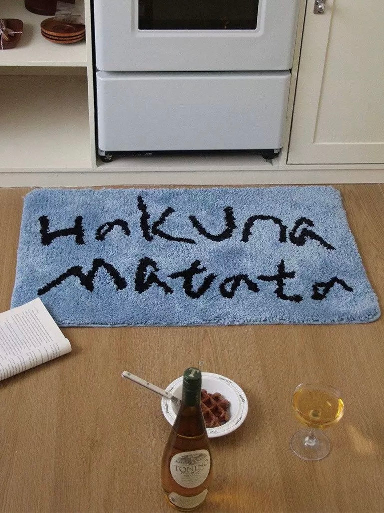 A blue rectangular mat displays two lines of black lettering near the oven, with its full front edge visible.