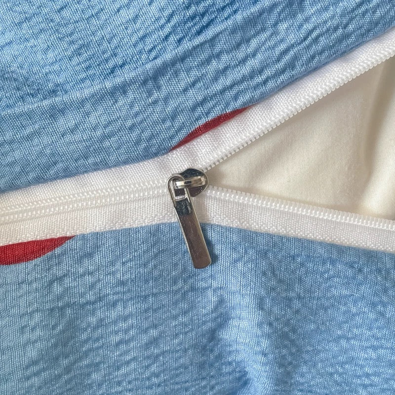 Soft blue polka dot bedding with red dots creating a playful yet cozy bedroom vibe for teens and students.