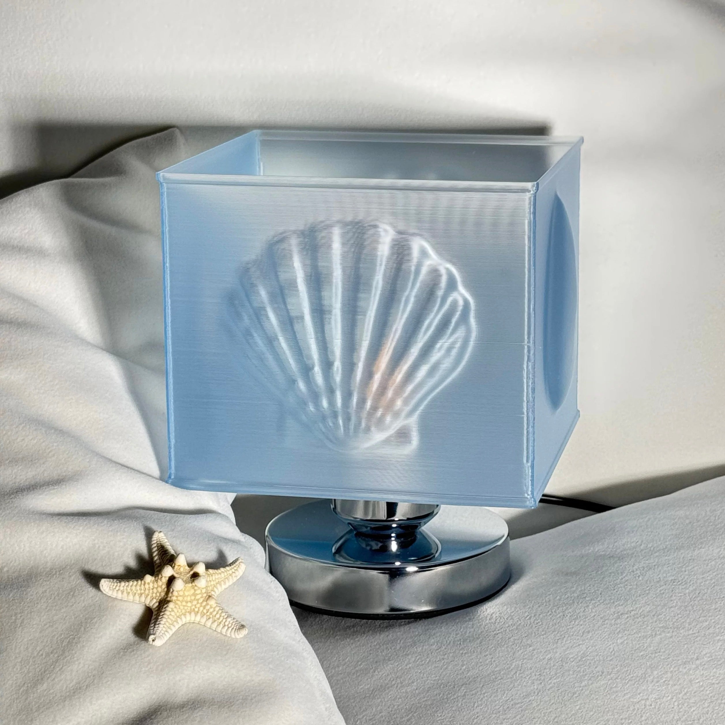 Mermaidcore style blue seashell lamp adding ocean vibes to bedroom nightstand styling