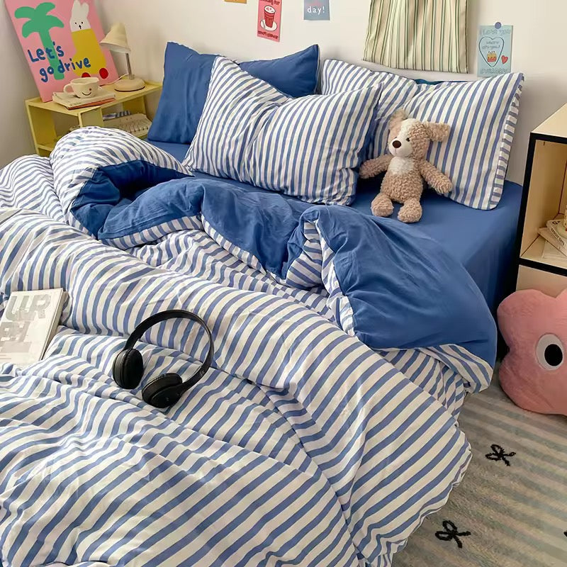 Minimalist small apartment styled with a blue stripe bedding set and cozy rug.