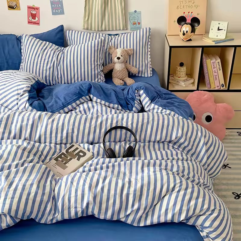 College student bedroom with aesthetic blue striped bedding and cozy room accessories.
