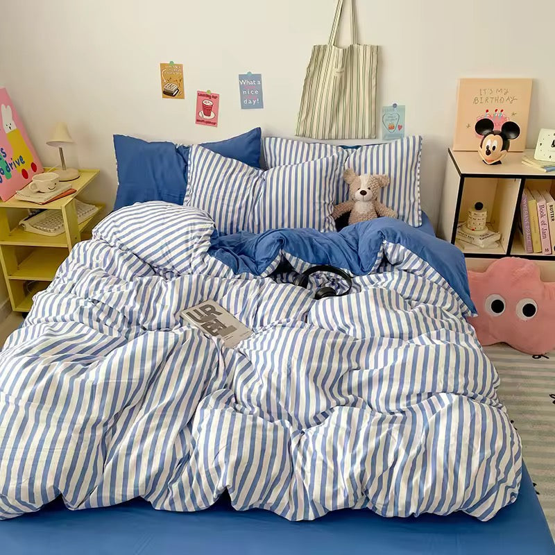 Cozy aesthetic blue striped bedding set styled with solid blue fitted sheet and plush accents.