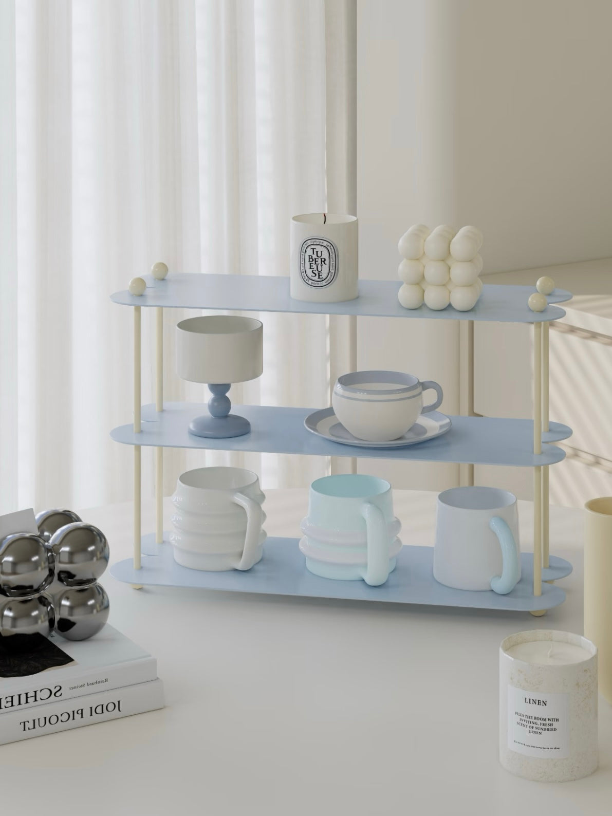 A blue tabletop shelf is shown at an angle, with cream posts, curved shelf ends and cups across the lower tiers.