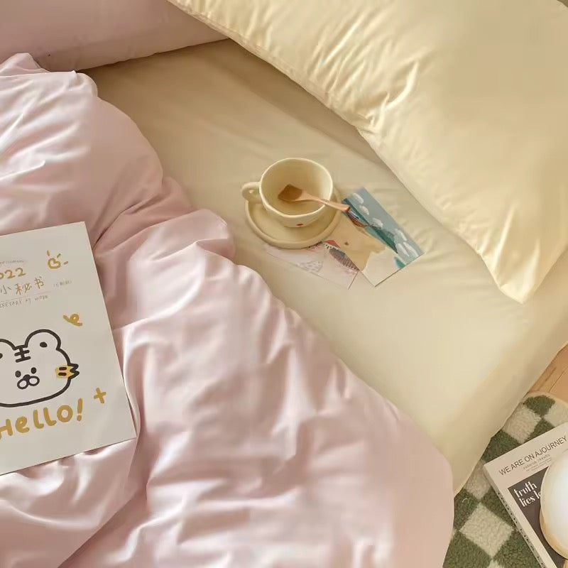 Soft pastel pink and cream bedding set styled with cozy blankets and aesthetic room decor.