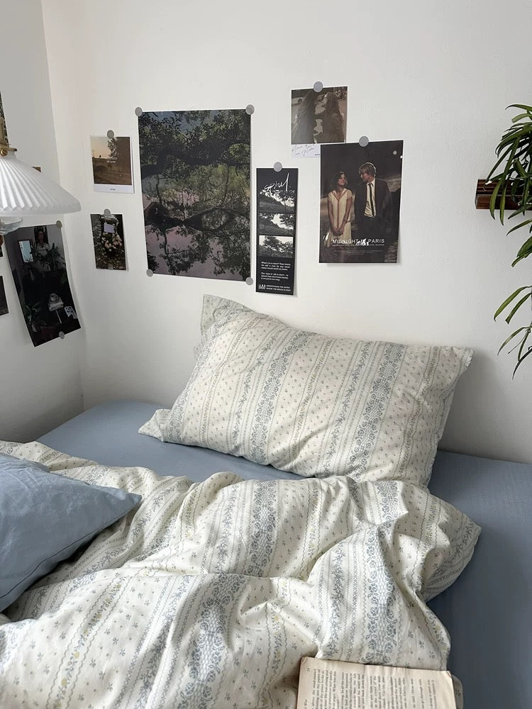Cotton floral bedding arranged with books, ceramics, greenery, and vintage artwork for peaceful home styling inspiration today.