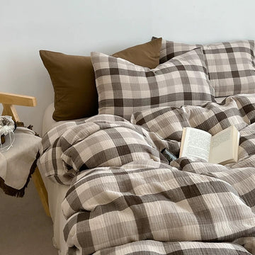 Brown check duvet cover set styled on a bed with a solid cognac accent pillowcase