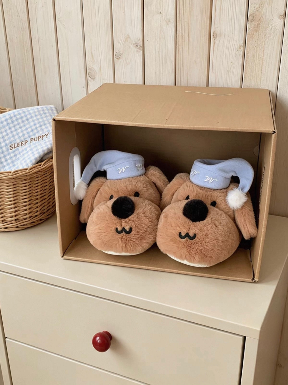 Brown dog slippers displayed inside an open cardboard box