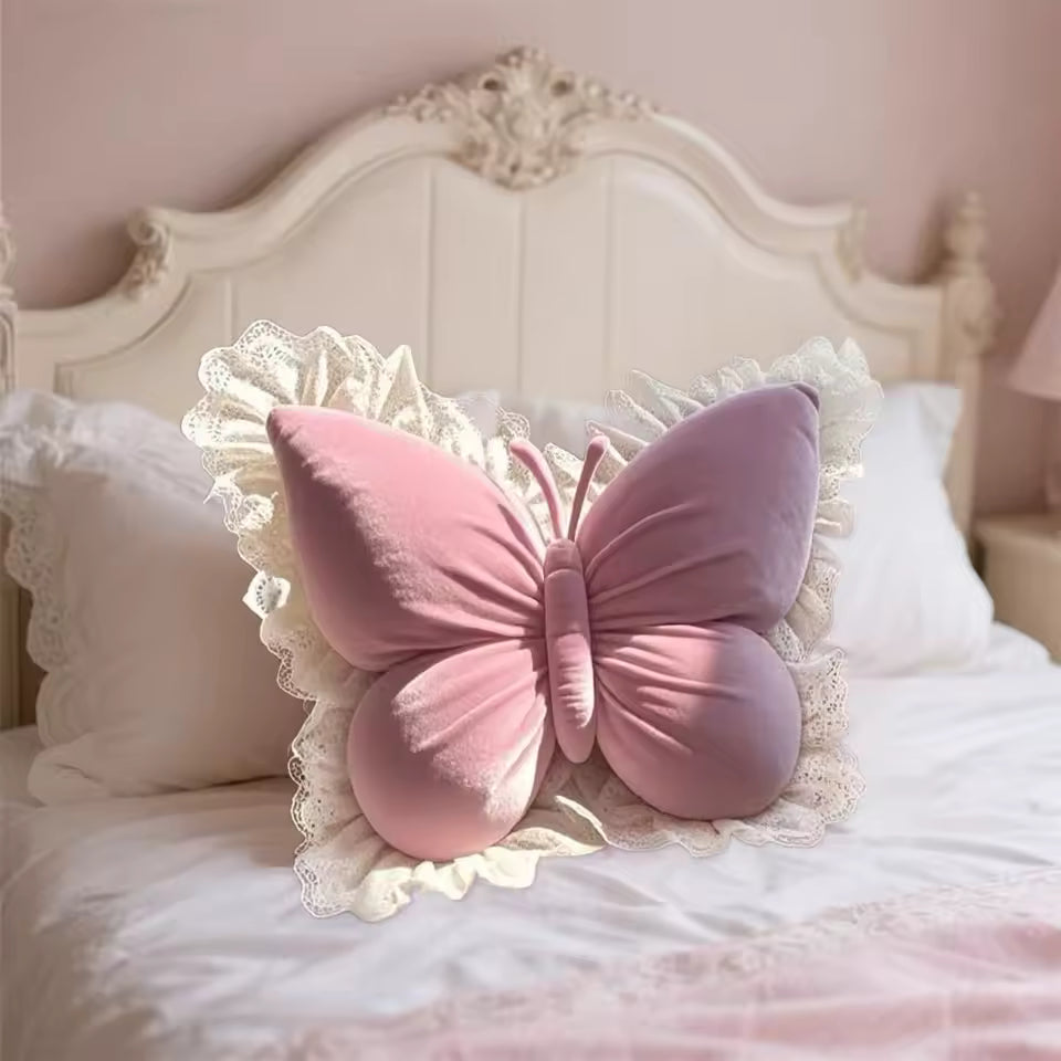 Pink butterfly decorative pillow with lace ruffle trim on a white bed