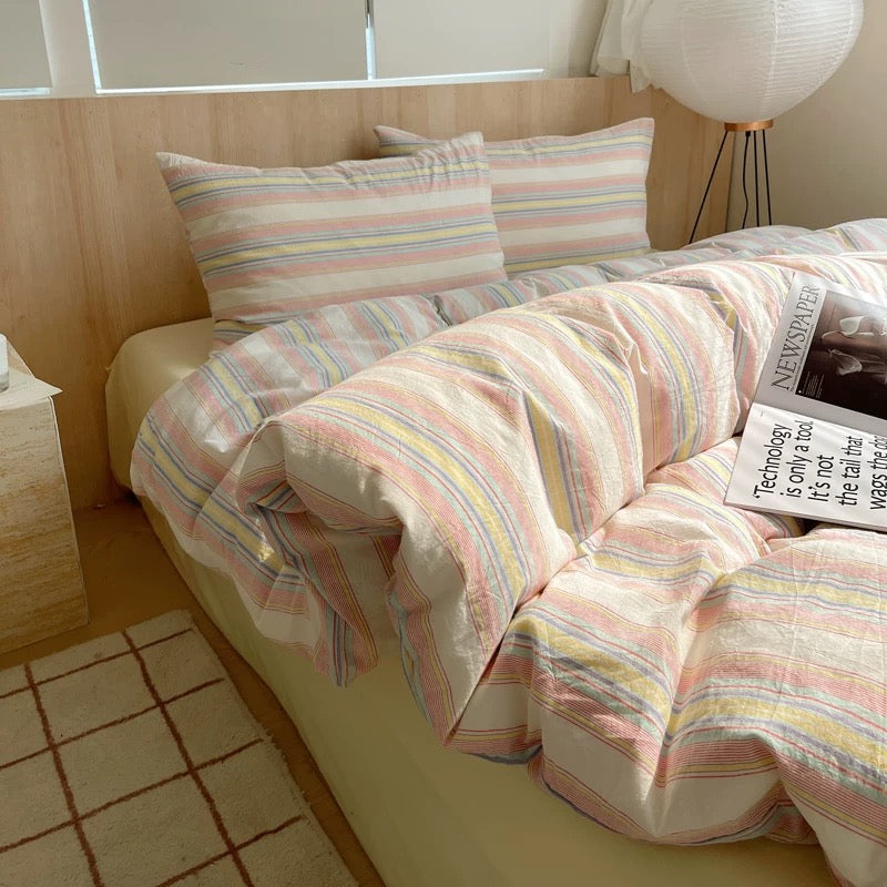 Bed with striped bedding and pillows in a bedroom setting