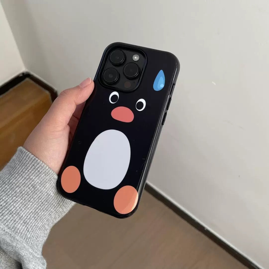 Phone case with a cartoon penguin design held by a hand against a neutral background