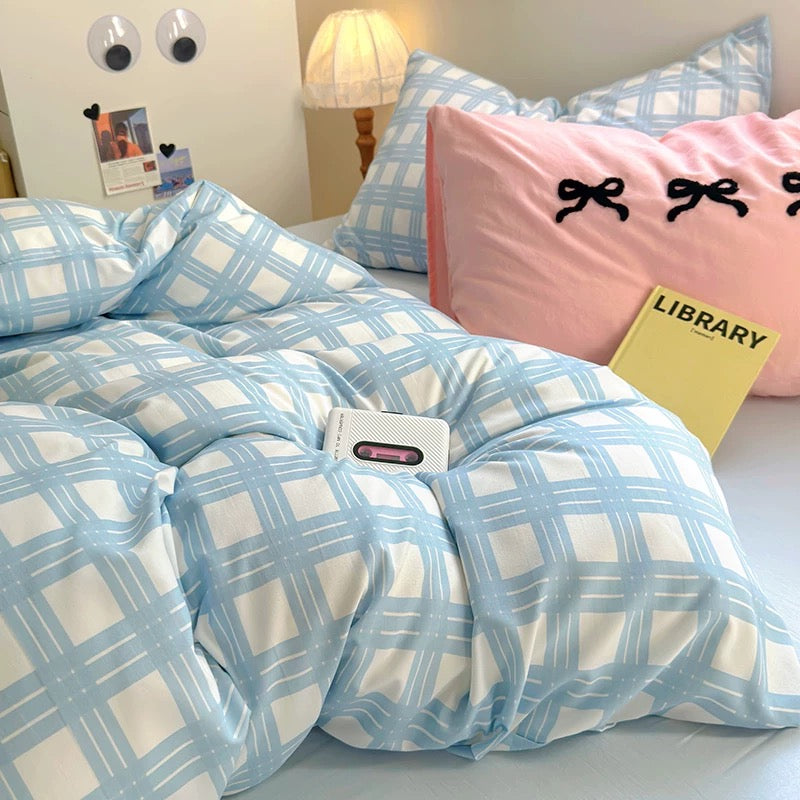 Product close-up showing the breathable cotton texture of the pastel comforter with check design